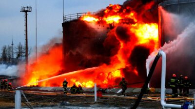  در ادامه حمله روسیه به اوکراین، امدادگران در محل تأسیسات ذخیره سوخت مورد اصابت موشک های کروز کار می کنند. 27 مارس 2022