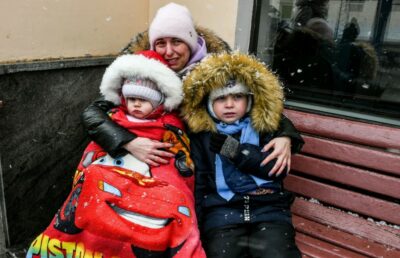 زنی با دو فرزند منتظر قطار برای فرار از حمله روسیه است. 7 مارس 2022 