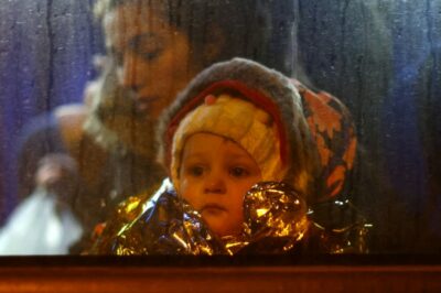یک کودک پس از عبور از مرز اوکراین به لهستان از پنجره اتوبوس به بیرون نگاه میکند