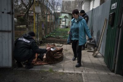 یک پلیس جسد مردی را که در جریان جنگ در بوچا کشته شد معاینه می کند. دوشنبه 11 آوریل 2022 