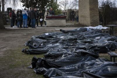 یک خانواده عزادار یکی از بستگان کشته شده‌اند، ده ها کیسه سیاه حاوی اجساد قربانیان در گورستانی در بوچا پراکنده شده است. 11 آوریل 2022