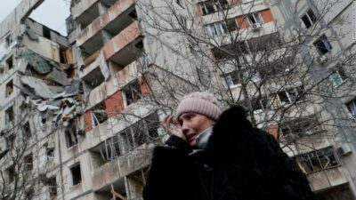 یک زن اوکراینی نزدیک یک آپارتمان ویران شده در شهر بندری محاصره شده ماریوپل می‌گرید. 17 مارس 2022