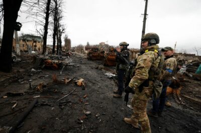 سربازان اوکراین برای دیدن خودروهای نظامی نابود شده روسیه قدم میزنند. 2 آوریل 2022