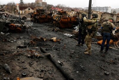 سربازان اوکراین برای دیدن خودروهای نظامی نابود شده روسیه قدم میزنند. 2 آوریل 2022